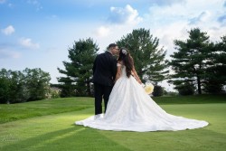 a bride and groom kissing on a golf course