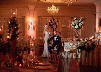 a bride and groom in their wedding reception area, full of flowers