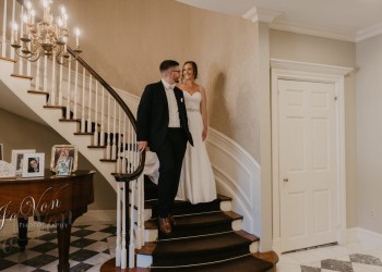 a bride and groom walking down a staircase