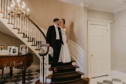 a bride and groom walking down a staircase