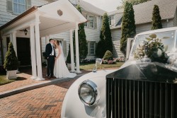 a bride and groom kissing infront of the royalton mansion