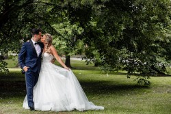 a bride and groom kissing under a large tree