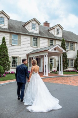 a bride and groom walking towards the royalton mansion