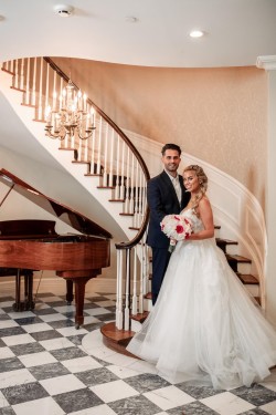 a bride and groom taking a photo at the bottom of a staircase