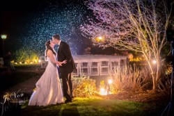 a bride and groom outside, kissing