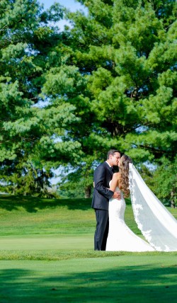 a bride and groom kissing, on a golf course