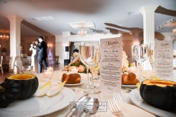 a wedding reception table, showing the menu and some wine glasses