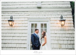 a bride and groom outside, by a doorway into the royalton mansion