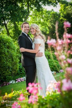 a bride and groom, outside, surrounded by pink flowers