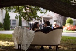 a bride and groom sitting on a couch outside the royalton mansion
