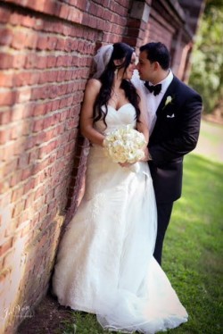 a bride and groom posing on the side of a building