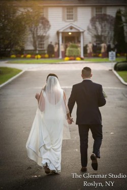 a bride and groom walking towards the royalton mansion